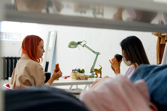 Young female fashion colleagues having coffee break