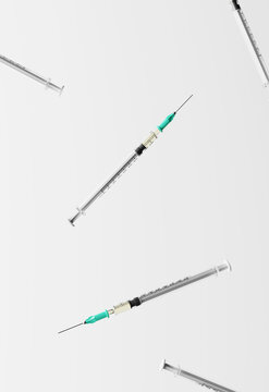 Syringes falling against white background