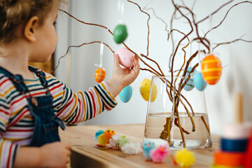 Toddler girl decorating for Easter