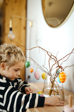 Toddler playing with colorful chicken figurines for Easter