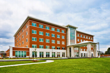 generic brown and white hospital facade with covered white entrance