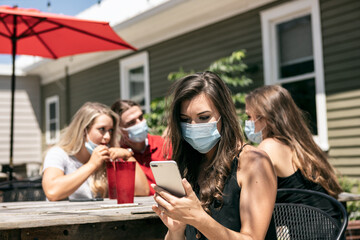 BBQ: Woman With Face Mask Uses Cell Phone Before Lunch