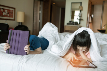 two children addicted tablet, asian kid watching cartoon