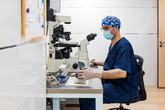 Medical specialist using microscope in IVF laboratory