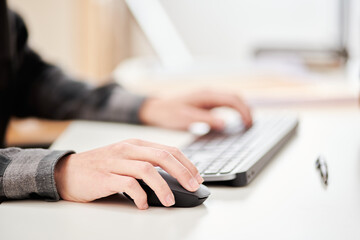 Crop man using computer mouse in office