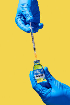 man fills a syringe with covid-19 vaccine