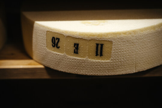 Close up of cheese resting on a wooden shelf