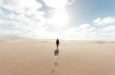 Woman walking at the desert with a camera