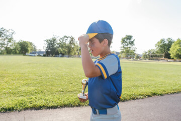 Baseball player holding trophy.