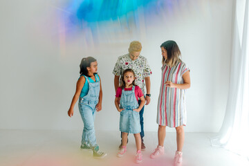 Same sex moms and girls near window