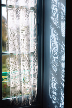 A blue window with a lace curtain