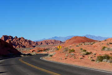 Fototapeta na wymiar Winding scenic empty road in the desert through sandstone rocks. Blue sky.
