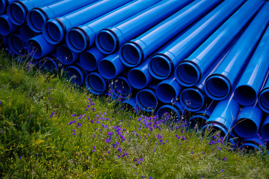Large blue water tubes placed next to flowers.