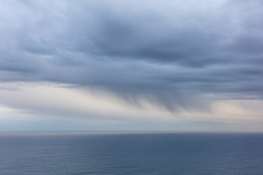 Clearing storm clouds over vast ocean