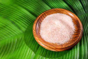 Fine grains of pink himalayan salt in the wooden bowl