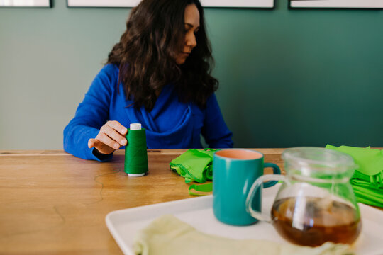 Woman holding a green thread reel