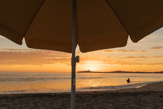 A surfer in the ocean at sunset