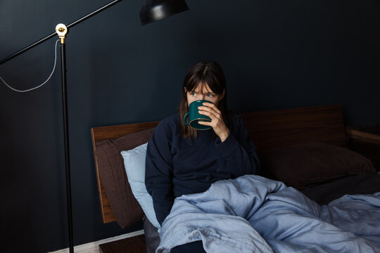 Woman drinking coffee in bed