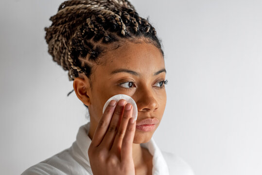 Black woman applying tonic on face
