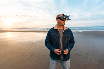 Man controlling drone in glasses of virtual reality on beach 
