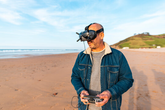 Man in VR headset controlling drone at seaside 