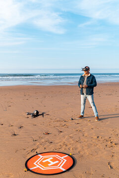 Man in VR headset controlling drone at seaside 