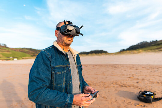 Man in VR headset controlling drone at seaside 