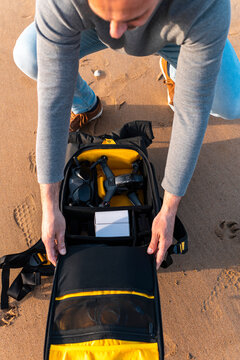 Man preparing backpack with drone for flight 