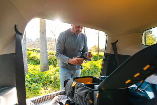 Adult male preparing backpack with drone for flight 