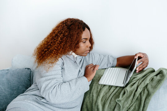 Woman using small laptop on the couch 