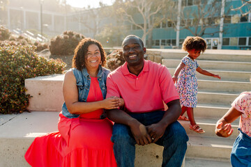 Smiling Black couple sitting outdoors 