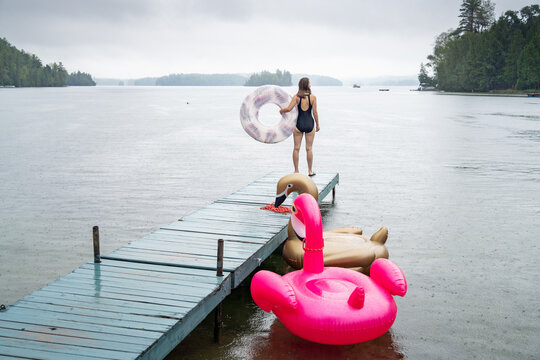 Young Woman Going for a Swim in the Rain at Summer Cottage Vacation Lake