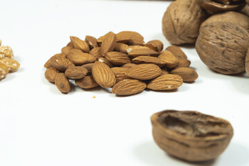 group of almonds with some walnuts on white background blurry nutshell selective focus dry fruits