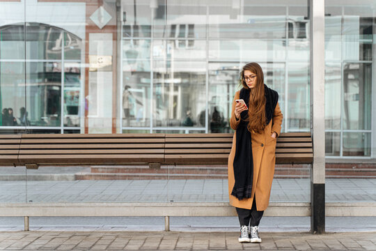Young female using smartphone on bus stop