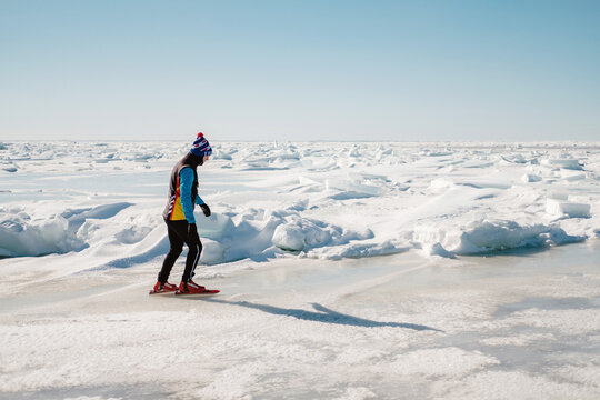 A man skates on the ice of a bay or lake