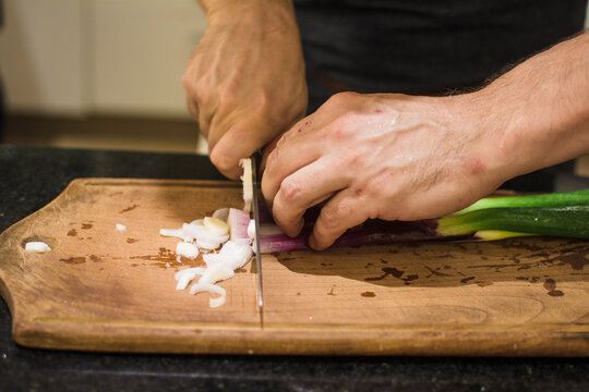 Unrecognisable man chopping sprin onion