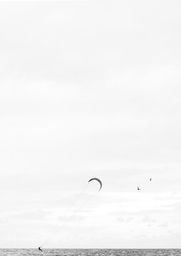 Minimalist picture of kite surfer riding the waves