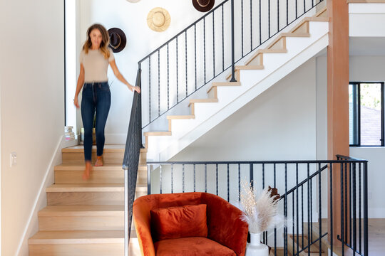 Woman Walks Down Stairs in a Bright House