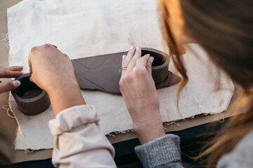 Hands forming clay vessels for ceramics production