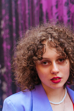 Portrait Of Curly Haired Woman In Purple Blazer