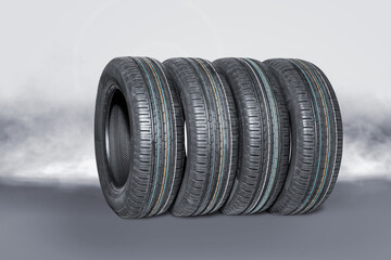 Four summer car tires on a creative smoke background