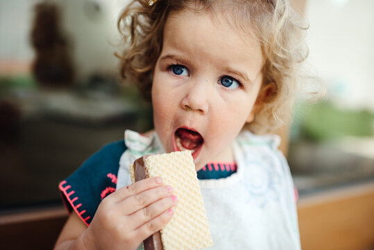 Close up of a young girl eating ice cream outdoors