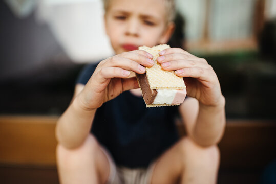 Close up of a young boy eating ice cream outdoors