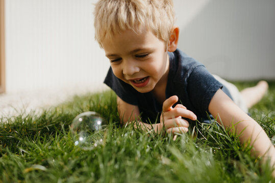 Young boy with soap bubble in the grass
