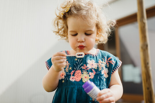 Young girl blowing bubbles outdoors