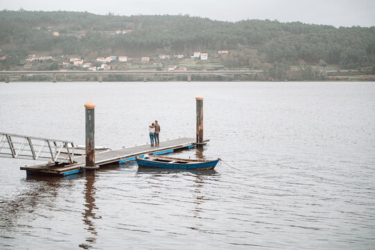 Couple standing on pier near boat