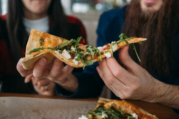 Slice of fresh hot pizza with mozzarella and lettuce
