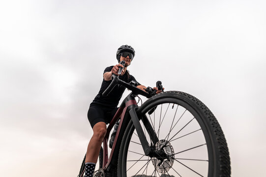 Sporty confident woman riding gravel bike in nature 