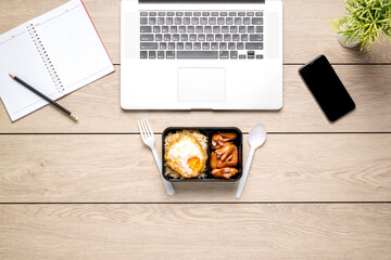 Online food delivery. Lunchtime. Lunch food is taking away boxes on the desk at home with notebooks and mobile phones at home, with copy space. New normal. stay home.