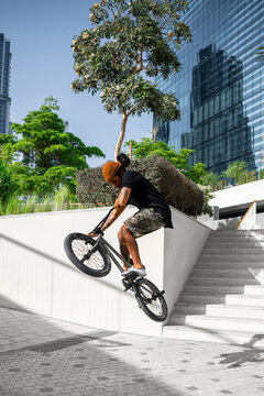 Portrait of a Young Tattooed man doing jumping trick on his BMX.